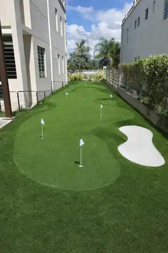 Putting green con varias banderas entre residencias