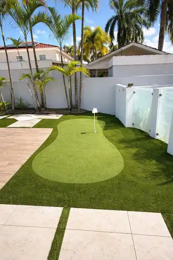 Putting green residencial junto a una terraza y palmeras
